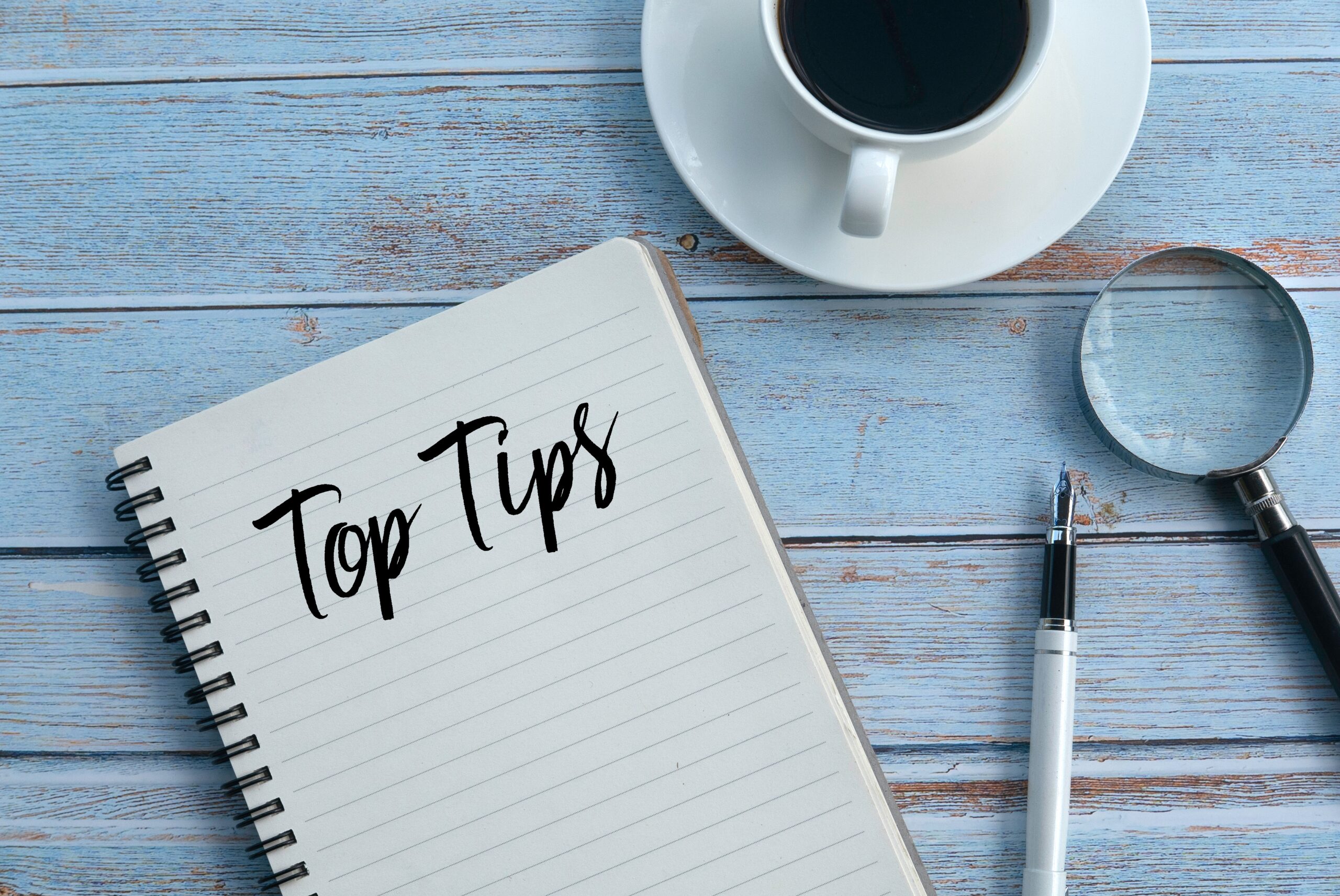 Notepad that says "Top Tips", next to a cup of coffee and pen.